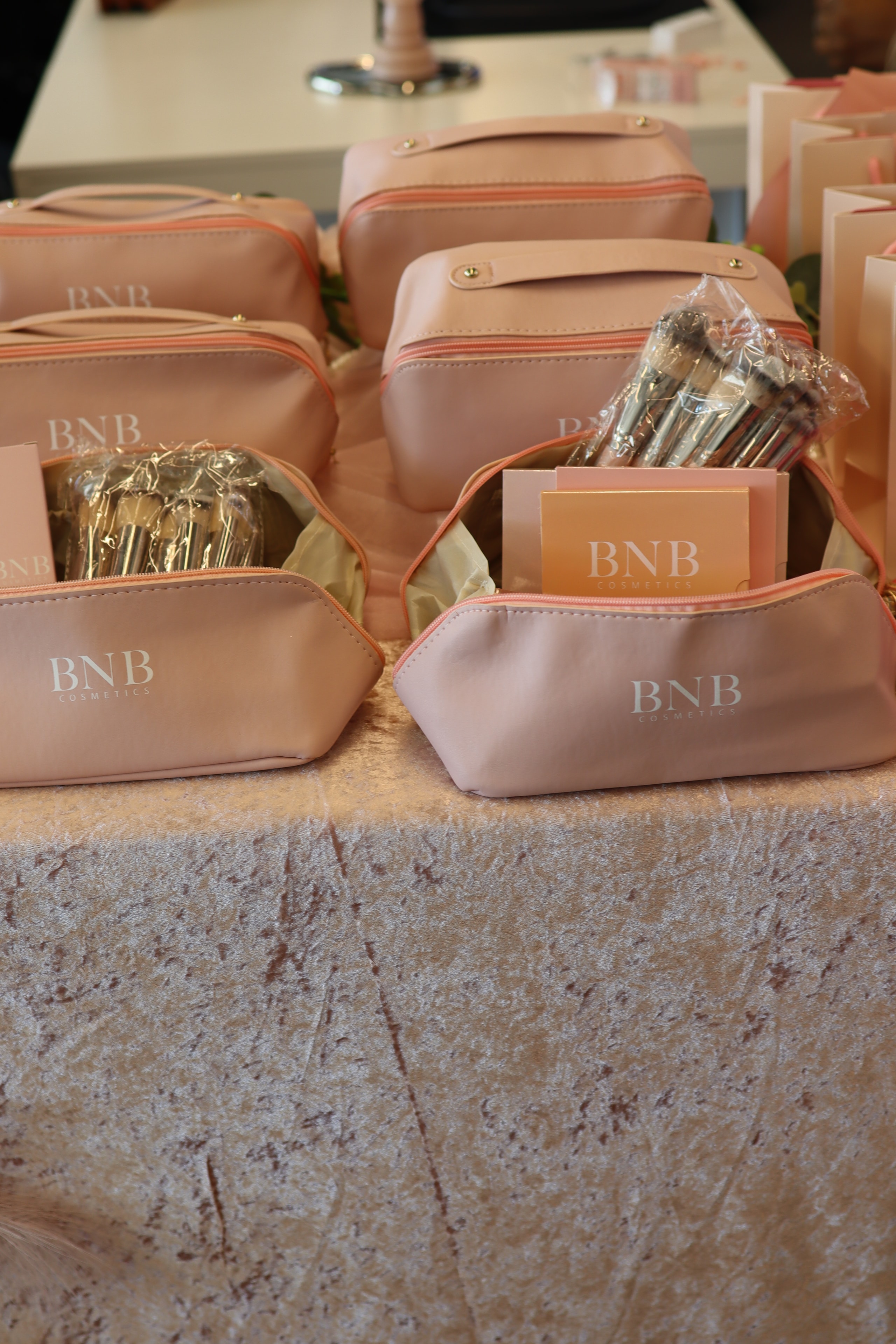 BNB Cosmetics branded makeup bags displayed on velvet surface
