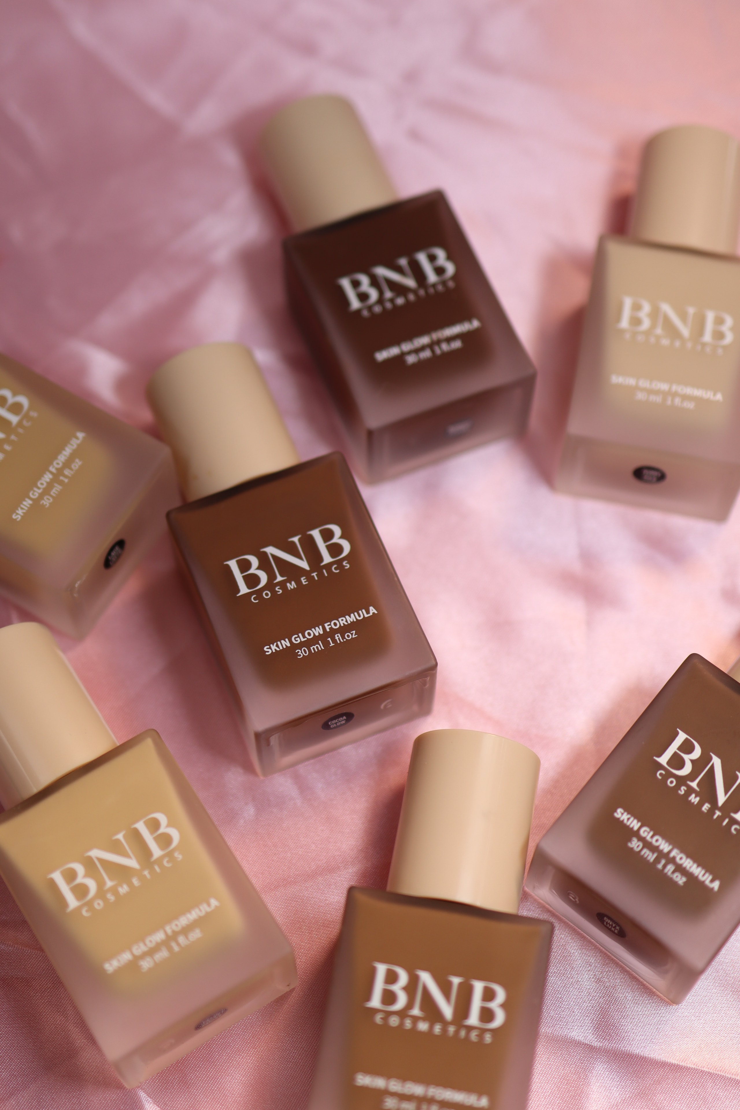 BNB Cosmetics Skin Glow Formula foundation shade range on pink fabric