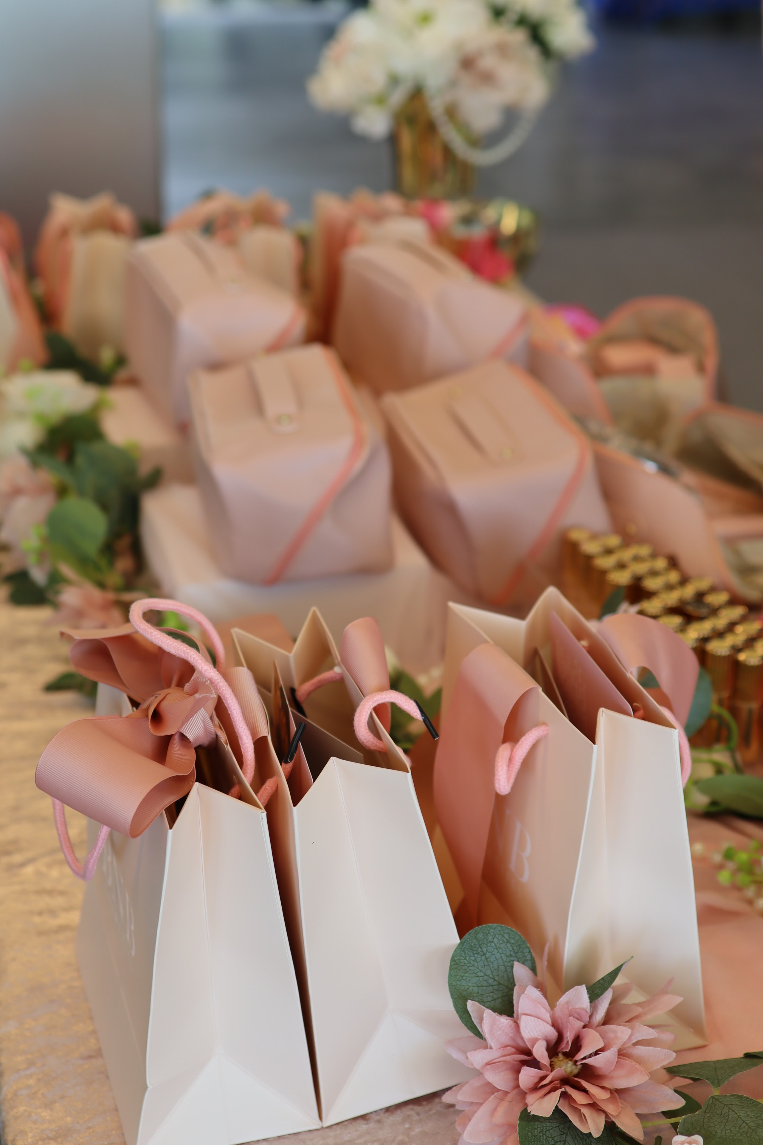 Stacked BNB Cosmetics gift bags with pink ribbon and florals