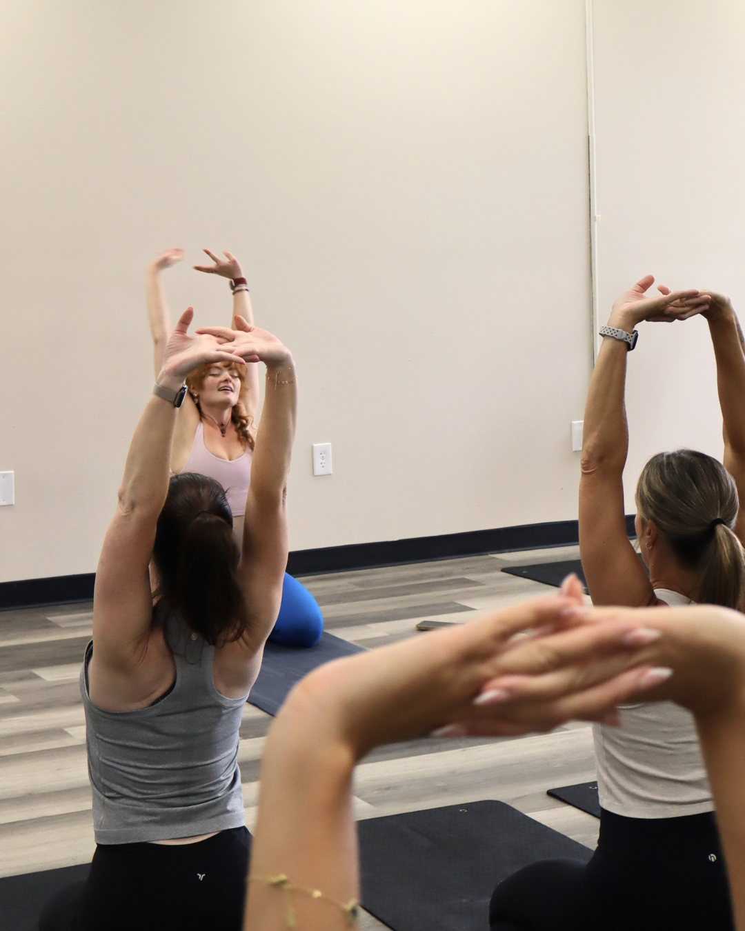 Women sitting on yoga mats holding puppies and smiling